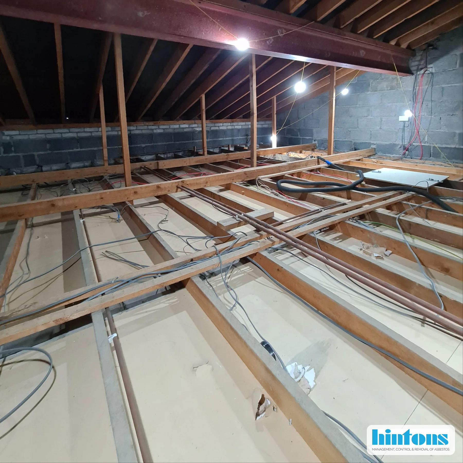 Community hall loft space during AIB debris removal project in North Wales