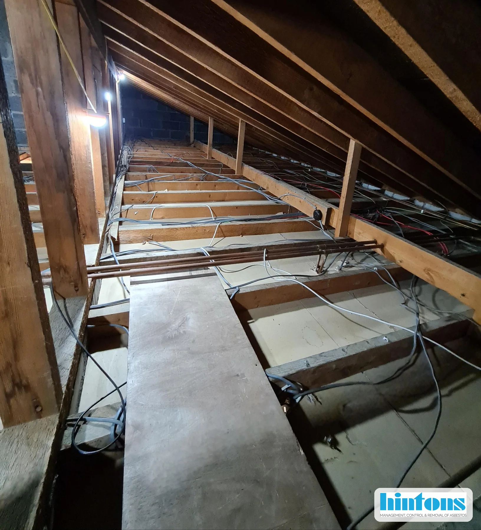 Loft access area during licensed asbestos insulation board debris removal in North Wales